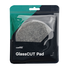 una confezione di CARPRO GlassCUT Pad, contenente 5 pad circolari da 130 mm di diametro. I pad sono di colore grigio e sono progettati per la lucidatura del vetro. La confezione ha una sezione trasparente che permette di vedere i pad all'interno.