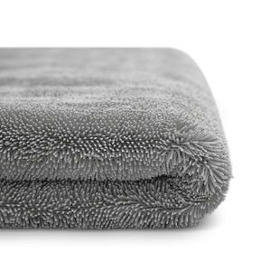 Vista laterale di un panno in microfibra grigio, piegato e ultra assorbente, ideale per asciugare l'auto senza lasciare segni o graffi.