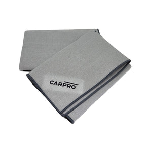 due panni CARPRO Glass Fiber piegati, realizzati in microfibra grigia di alta qualità. Uno dei panni ha il logo CARPRO visibile, cucito in nero. Questi panni sono progettati per la pulizia dei vetri senza lasciare aloni, garantendo una finitura perfetta.